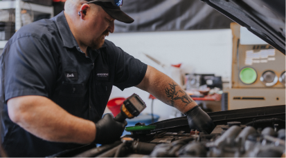 Technician working under hood of car | Andrew's Automotive Repair