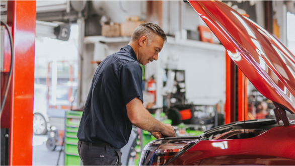 Technician working under hood of car | Andrew's Automotive Repair