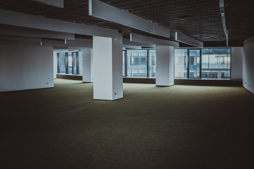 An empty room with a lot of windows and columns.