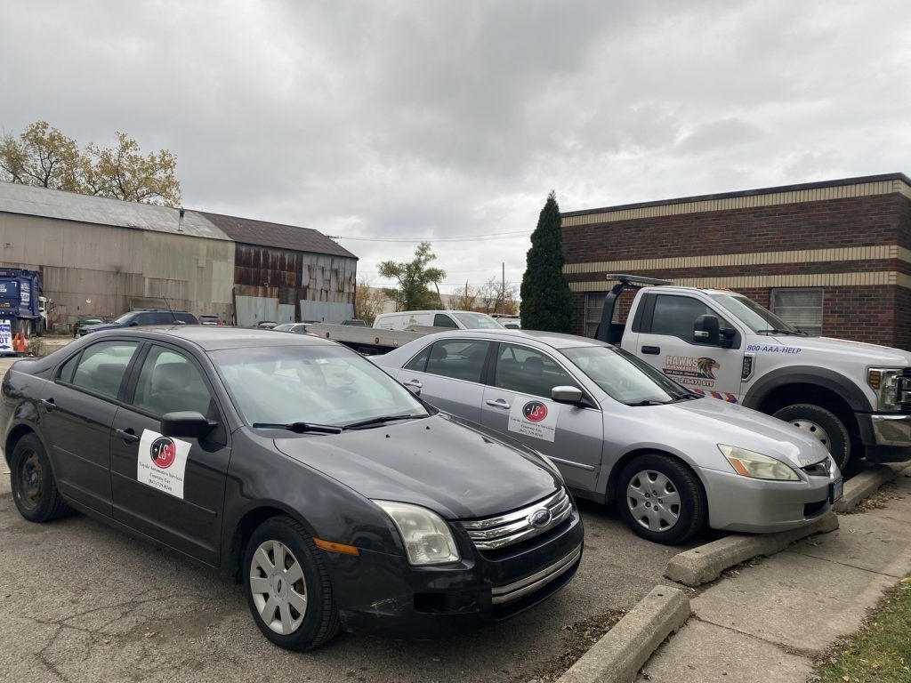 Cars parked outside a brick building on a cloudy day. | Loyola Service