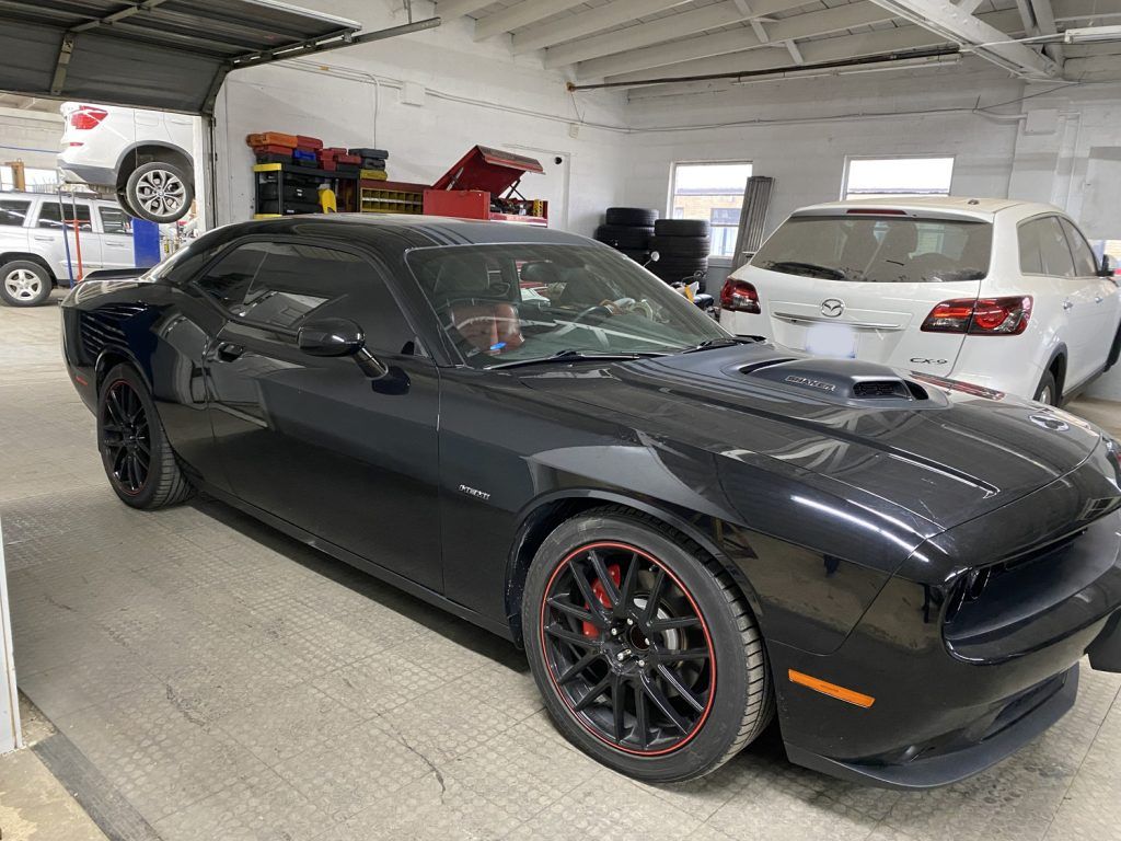 Black Dodge Challenger sports car in auto repair shop. | Loyola Service