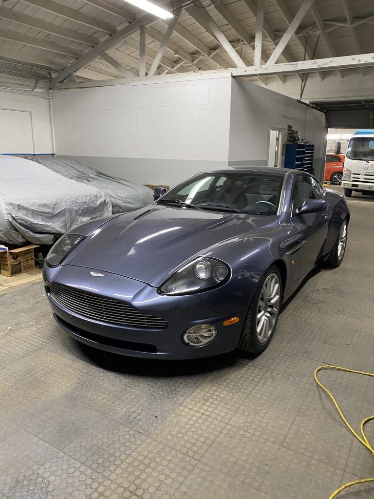 Blue Aston Martin sports car parked inside a garage. | Loyola Service