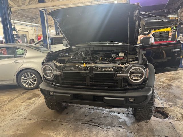 Black Ford Bronco with open hood in a repair shop. | Loyola Service