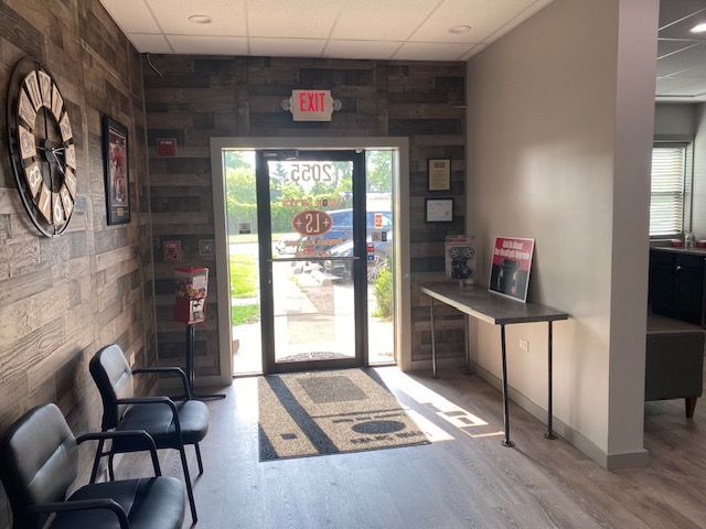Waiting area with chairs, door, and wooden accent wall. | Loyola Service