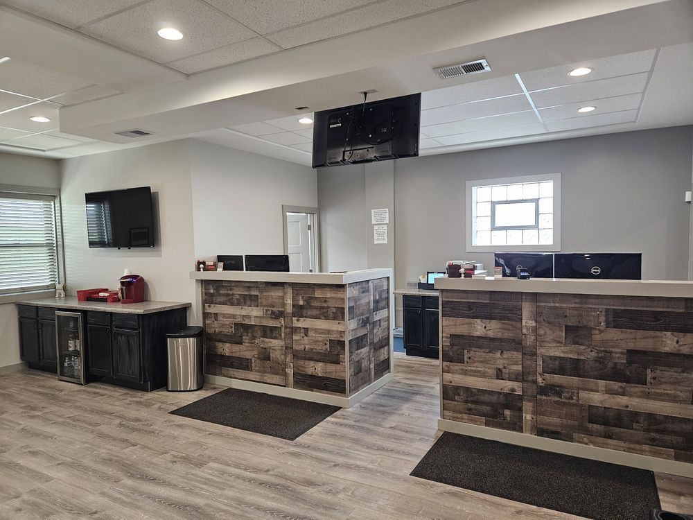 Reception area with wood-paneled counters, TVs, and a small window | Loyola Service