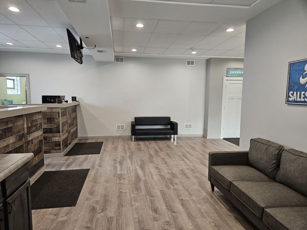 An office waiting area with a wooden reception desk, two couches, and a door | Loyola Service