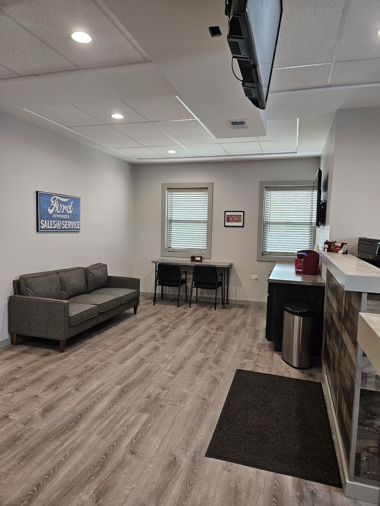 Waiting room with gray sofa, windows, desk, and a textured reception area | Loyola Service