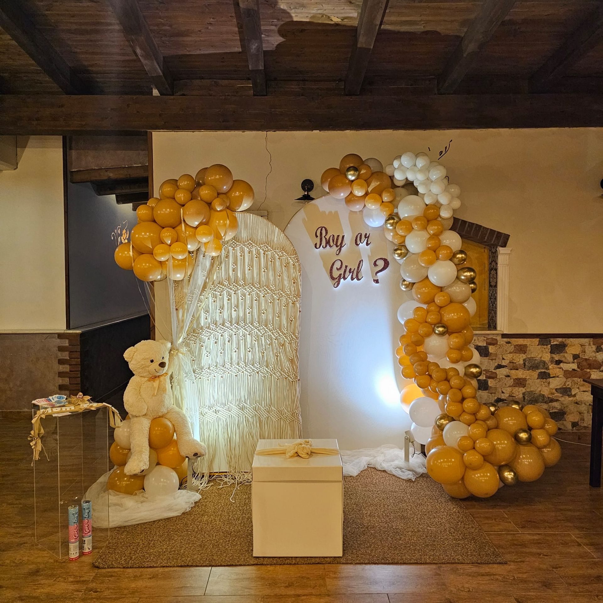 Festa per rivelare il sesso del nascituro con palloncini gialli e bianchi, un orsacchiotto e un cartello con la scritta