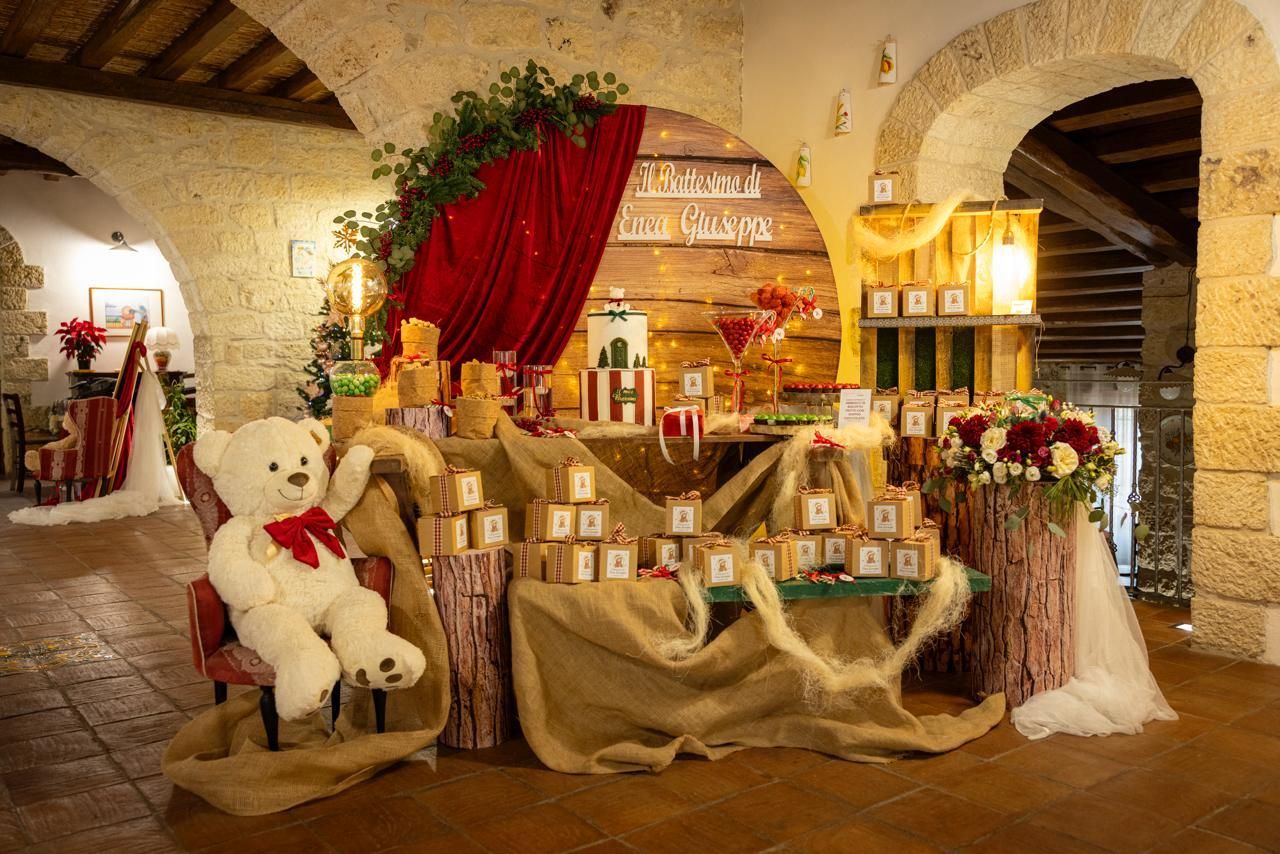 Ricevimento con decorazioni a forma di orsacchiotto, tela di iuta, legno, tenda rossa e composizioni floreali.