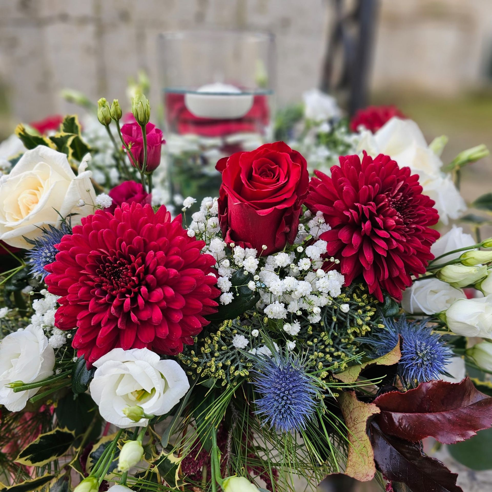 Composizione floreale rossa e bianca con candela galleggiante.