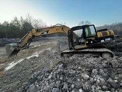 A bulldozer is loading sand into a pile.