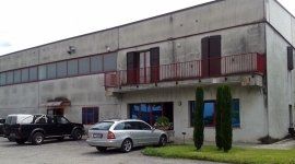 Davanti ad un grande edificio sono parcheggiate due auto.