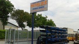 Una pila di tubi blu è seduta davanti a un cartello metalser.