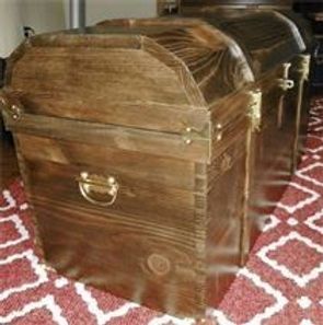 A large wooden trunk is sitting on top of a rug.