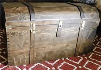 A wooden trunk is sitting on top of a rug.