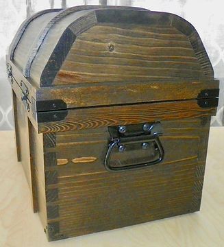 A wooden trunk with black handles is sitting on a table.