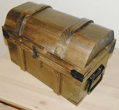 A wooden treasure chest is sitting on a wooden table