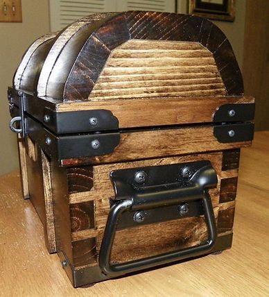 A wooden trunk with metal handles is sitting on a wooden table