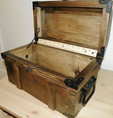 A wooden trunk with the lid open is sitting on a wooden table