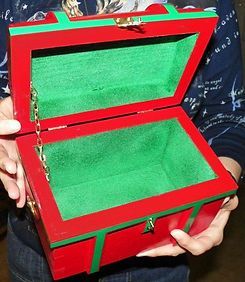 A person is holding a red and green box with the lid open