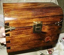 A person is holding a wooden box with a lock on it.