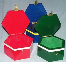 A red , blue , and green box are sitting next to each other on a table.