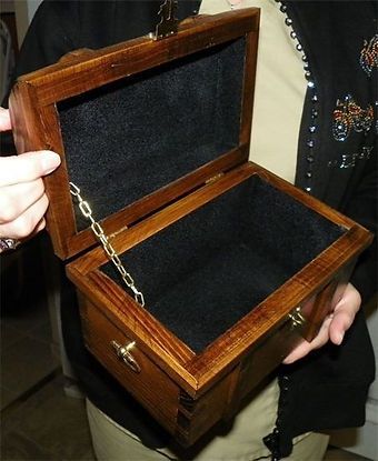A woman is holding a wooden box with the lid open