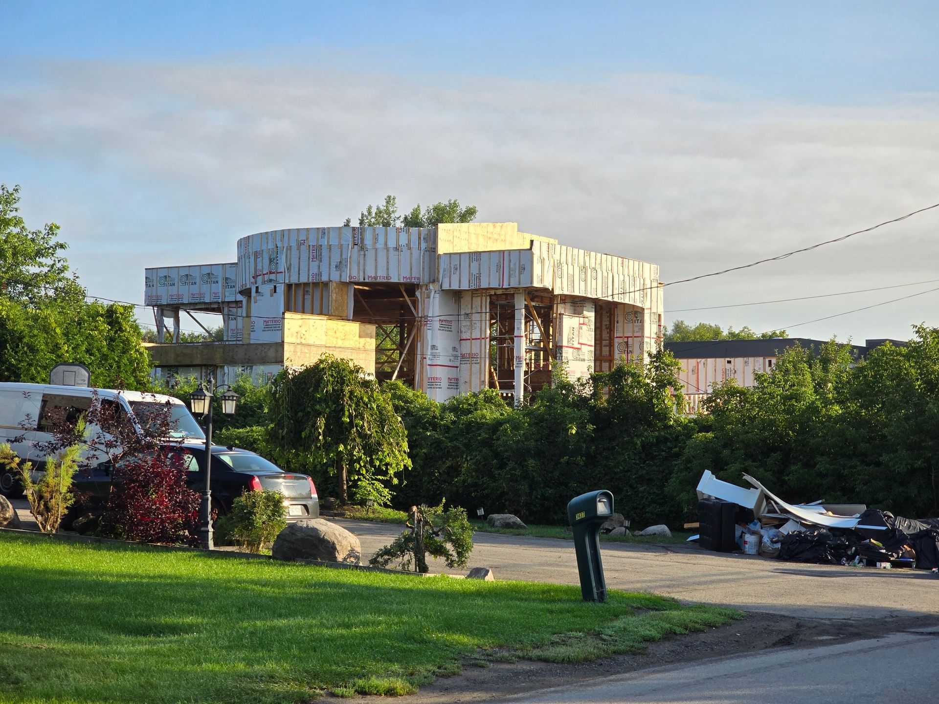 Une maison en construction avec une boîte aux lettres devant.