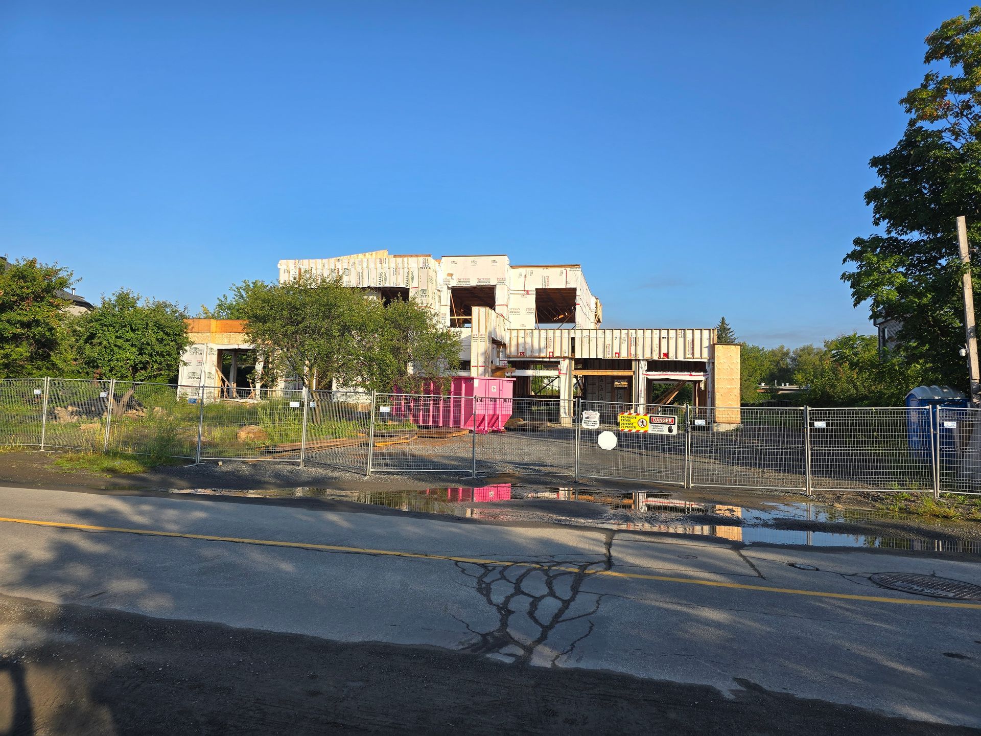 Une grande maison est en construction au milieu d'une zone clôturée