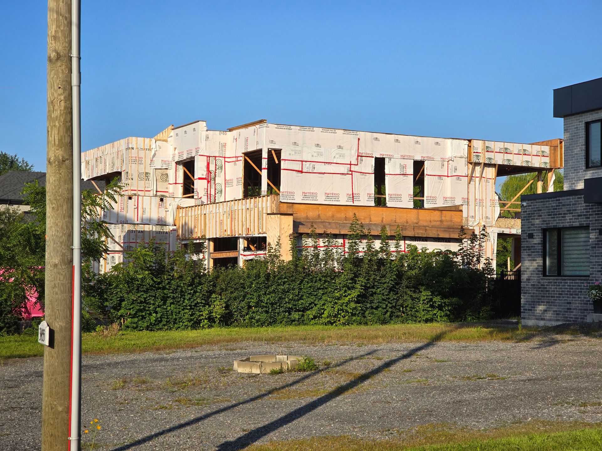 Une grande maison est en construction dans un quartier résidentiel.