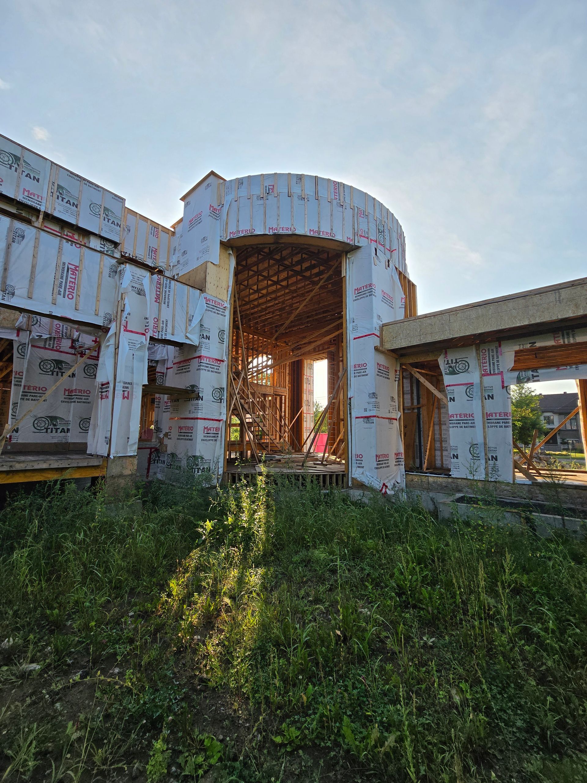Un grand bâtiment est en construction au milieu d'un champ.