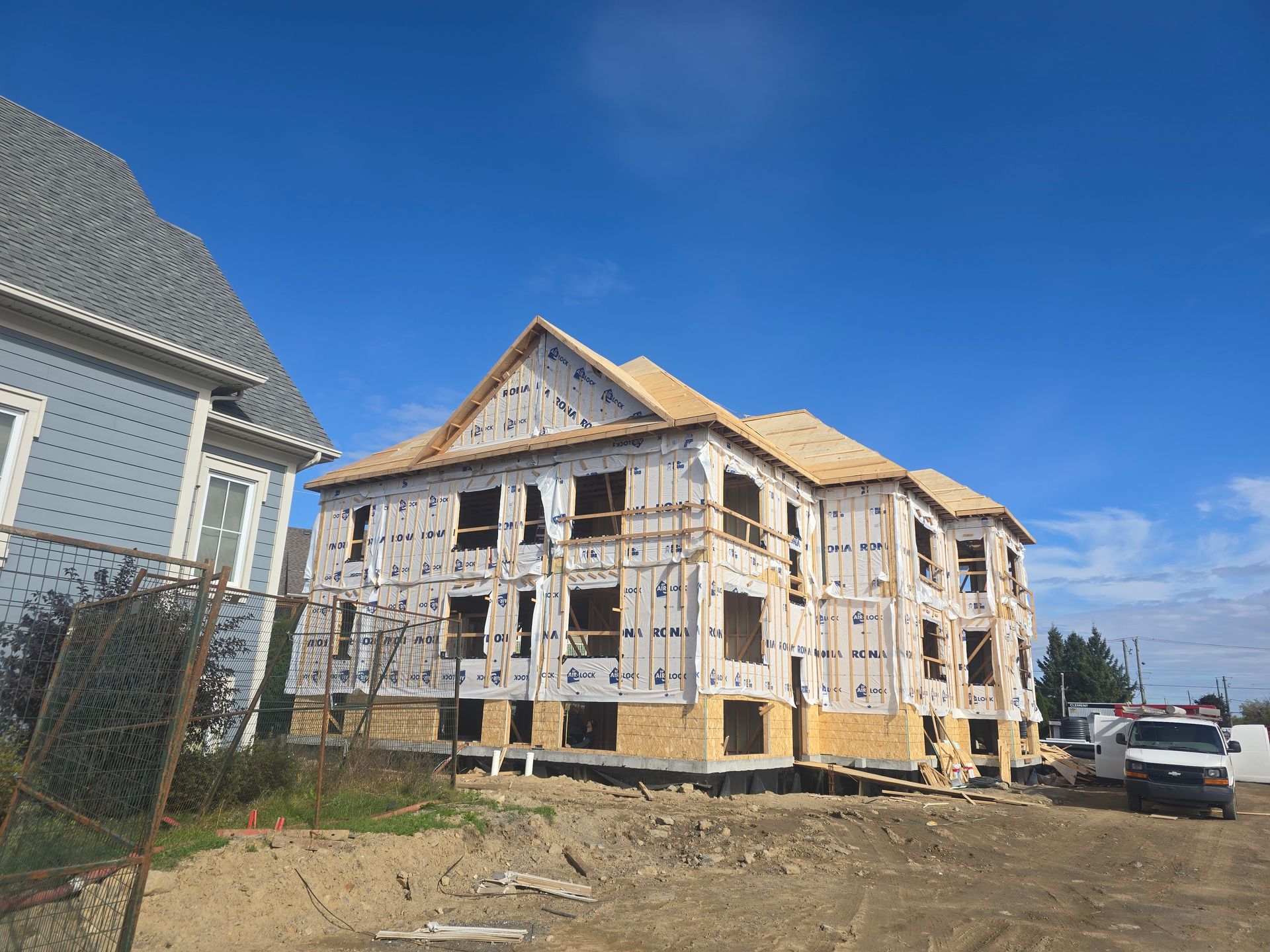 Un grand bâtiment est en construction à côté d'un bâtiment plus petit.