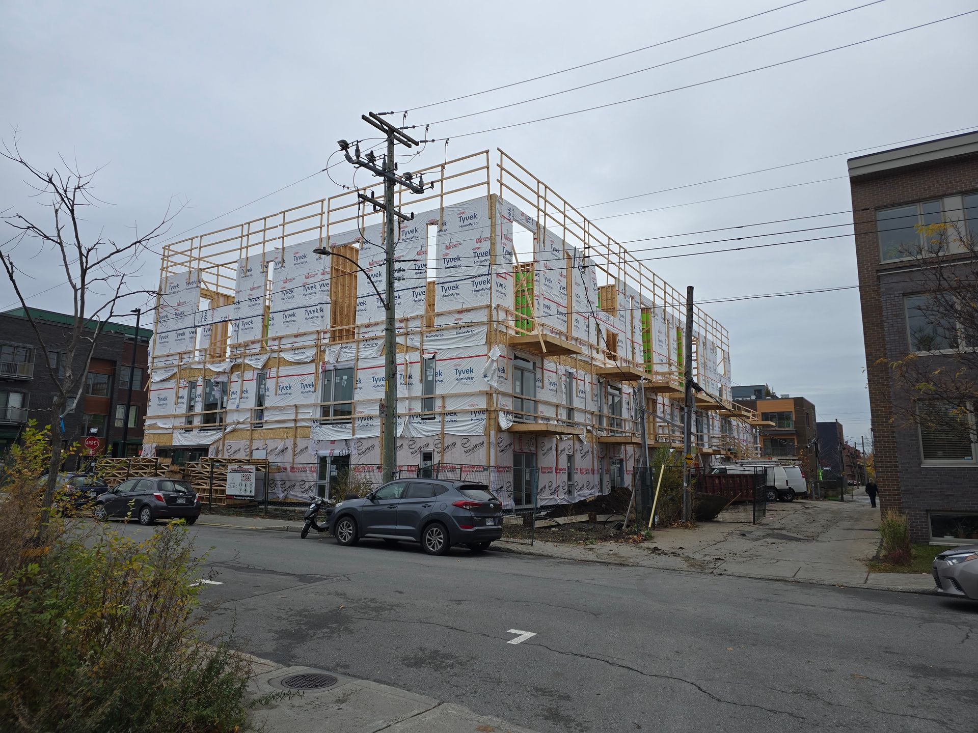 Une voiture est garée devant un immeuble en construction.