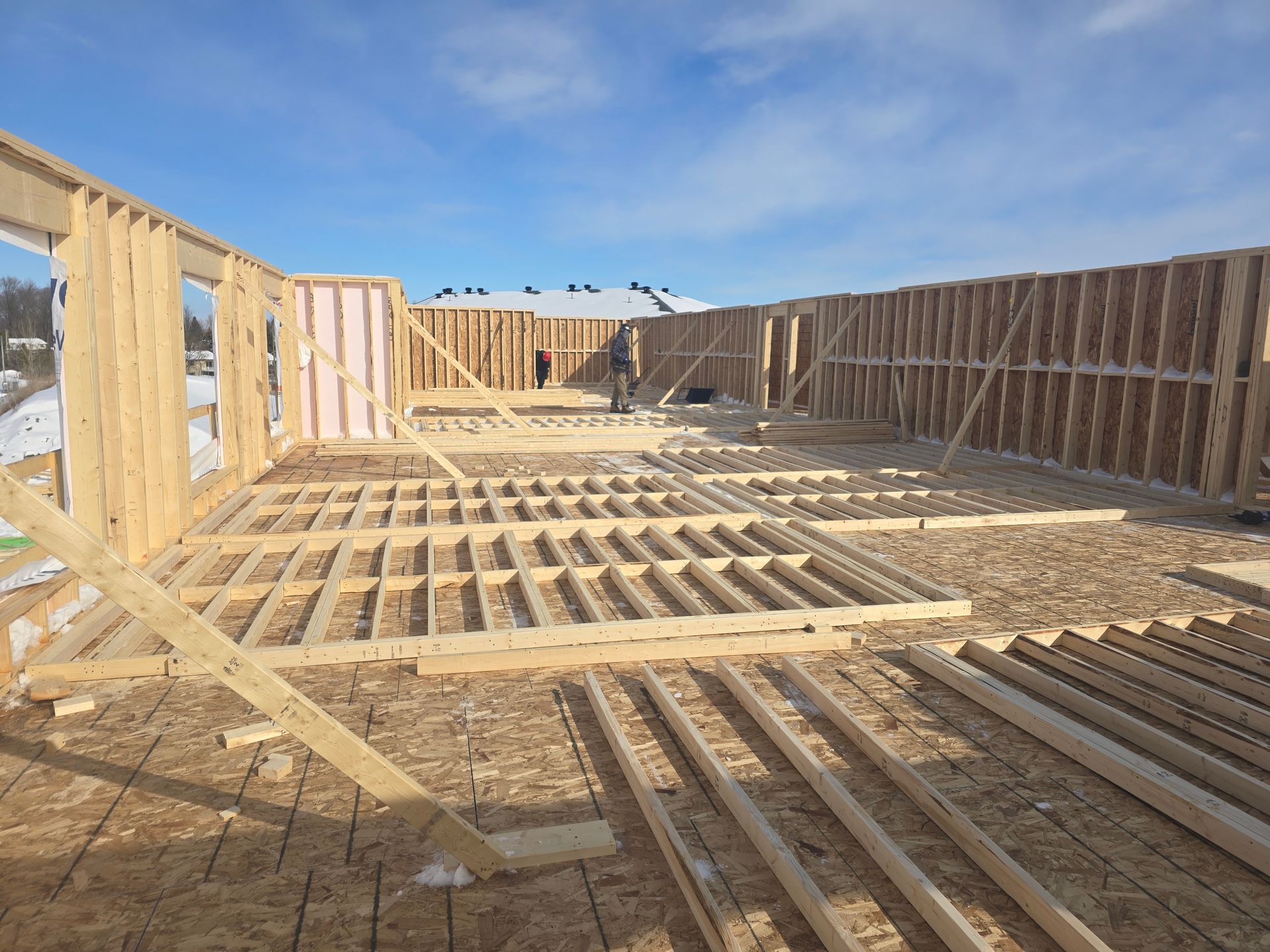 Une grande structure en bois est en train d'être construite dans la neige.