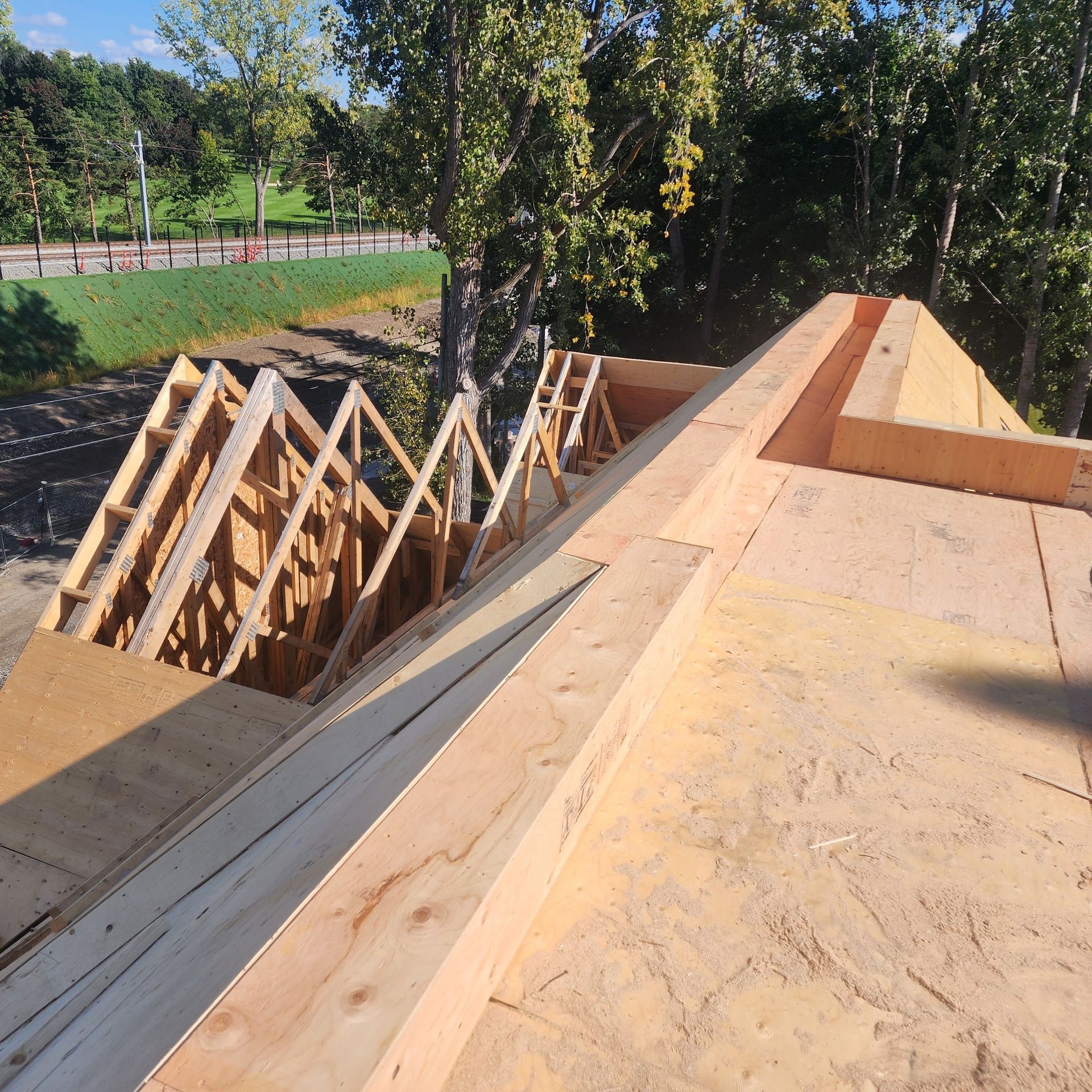 Une structure en bois est en cours de construction avec des arbres en arrière-plan
