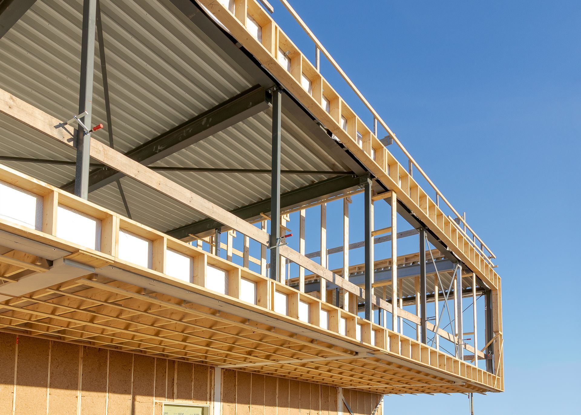 Un immeuble en construction avec un balcon et un ciel bleu en arrière-plan.
