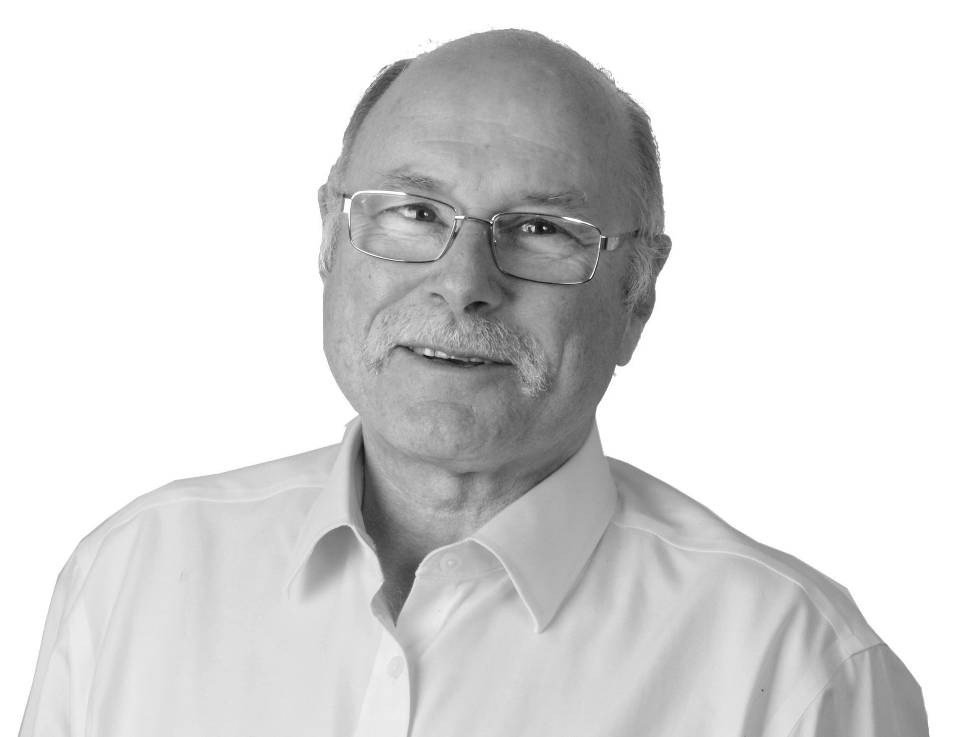 Smiling older man wearing glasses and a white shirt.