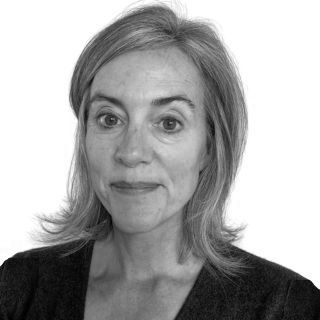 Woman with gray hair and a slight smile looking at the camera. Black and white headshot.