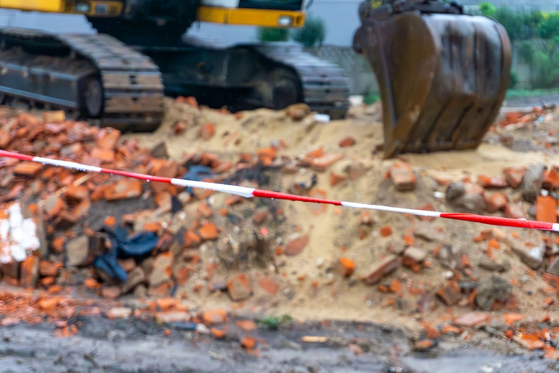 Demolition company excavator clearing debris and bricks at active construction site safely. Demolition company excavator clearing debris and bricks at active construction site safely.