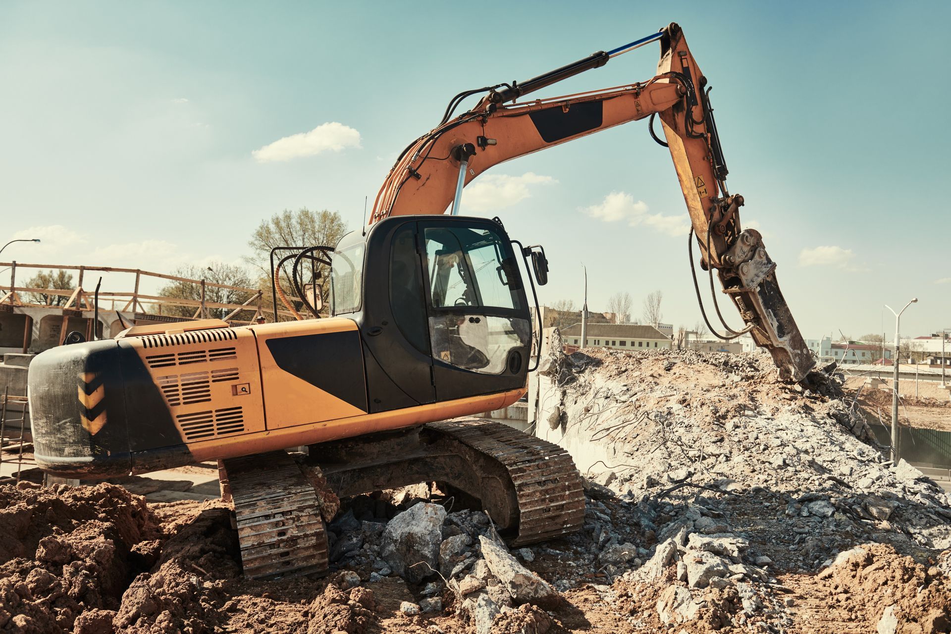 Demolition of an old building in the center city with heavy equipment. Hydraulic breaker hammer excavator at demolition site.