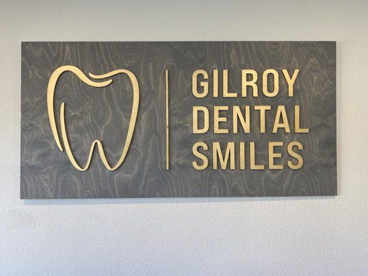 A sign for gilroy dental smiles with a tooth on it
