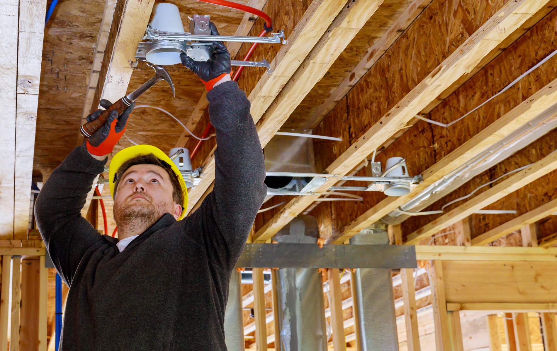 A man is working on the ceiling of a house under construction.