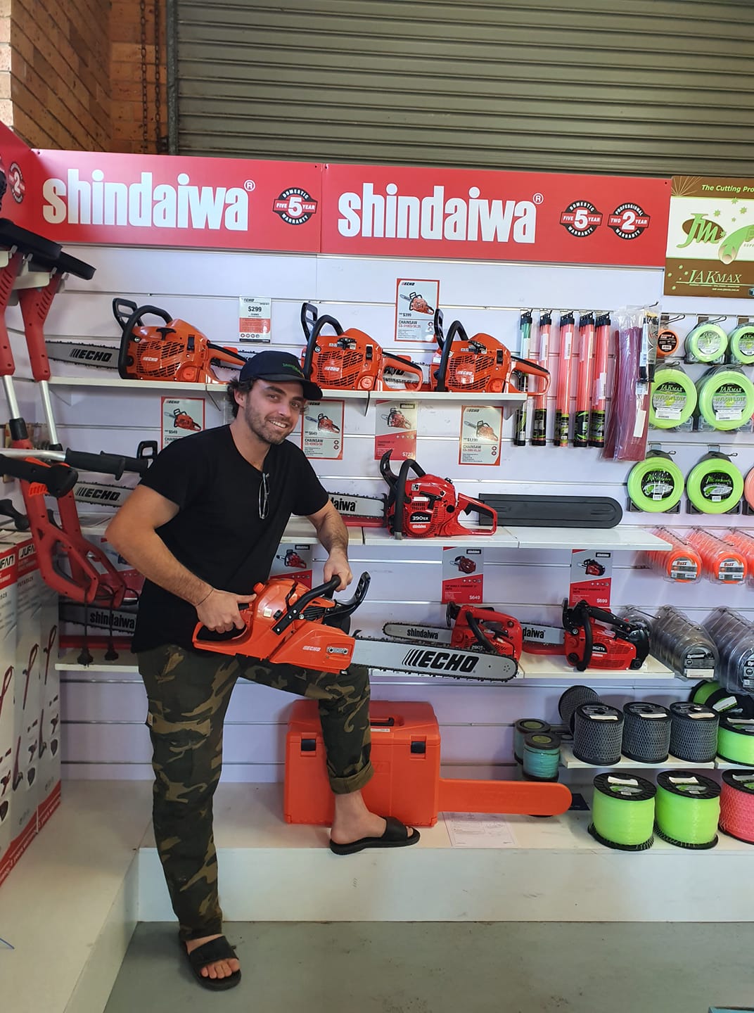Man Holding Echo Chainsaw — Great Lakes Mowers & Chainsaws In Tuncurry, NSW