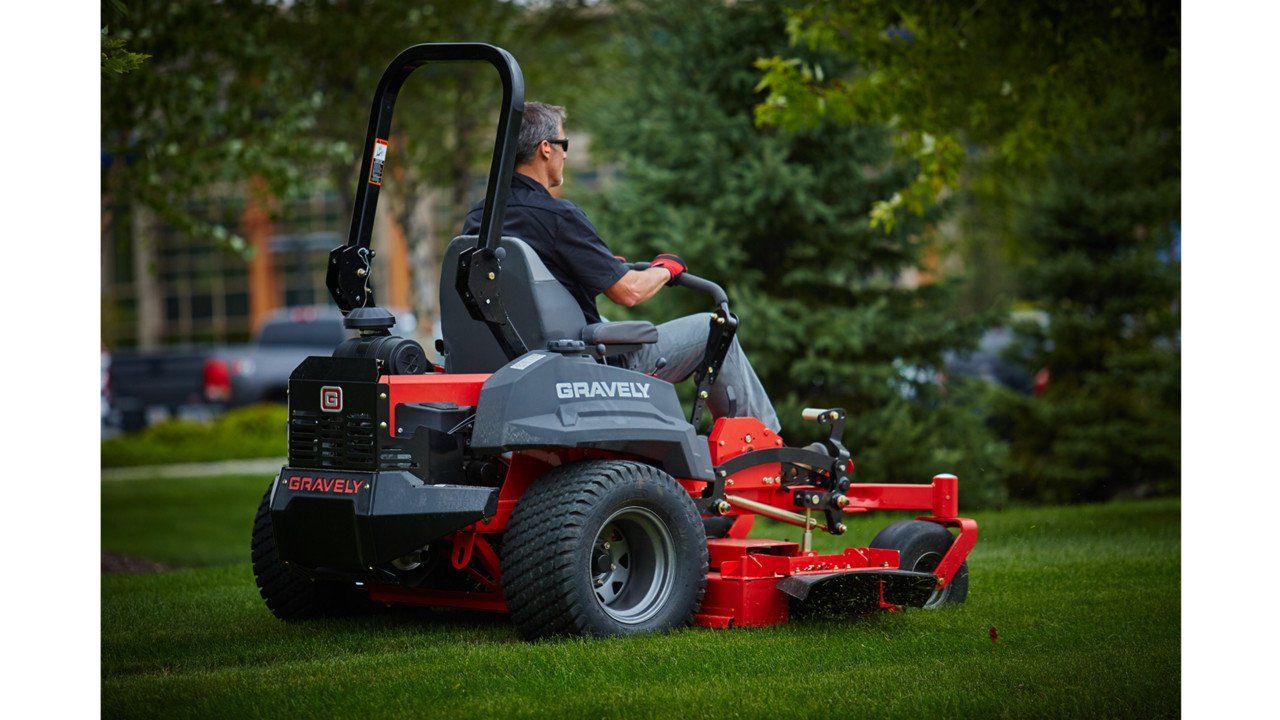 Man Riding a Ride-On Lawn Mower — Great Lakes Mowers & Chainsaws In Tuncurry, NSW