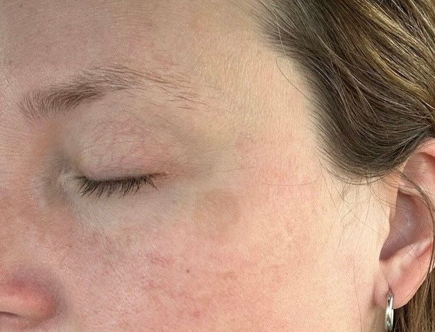 A close up of a woman 's face with her eyes closed.