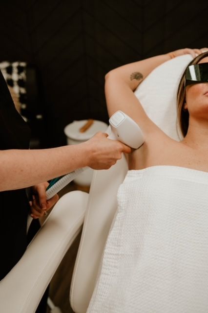 A person is getting a laser hair removal treatment on their underarm.