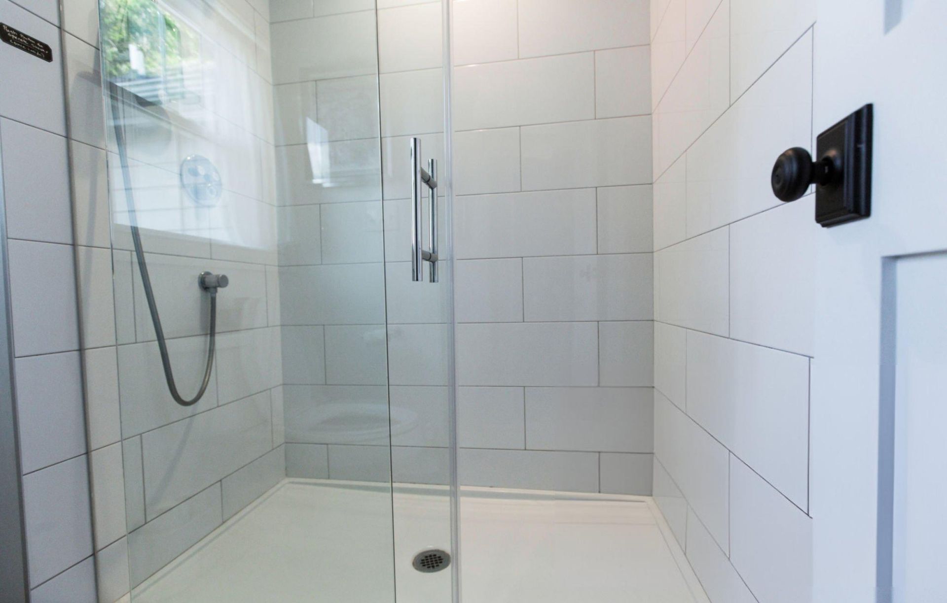Shower Door Installation in a white tiled bathroom showcasing sleek, modern, and clean design. Shower Door Installation in a white tiled bathroom showcasing sleek, modern, and clean design.