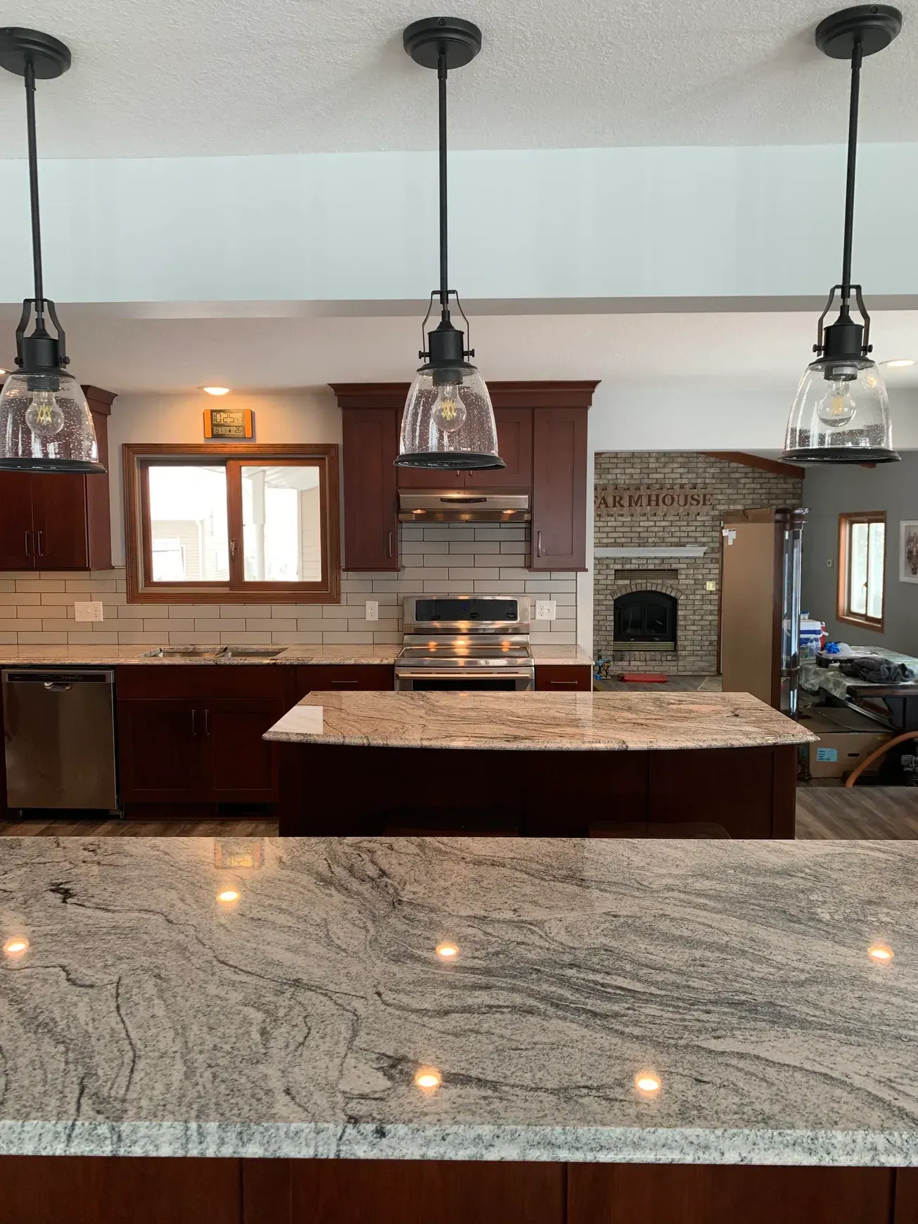A kitchen with granite counter tops , stainless steel appliances , and a large island.