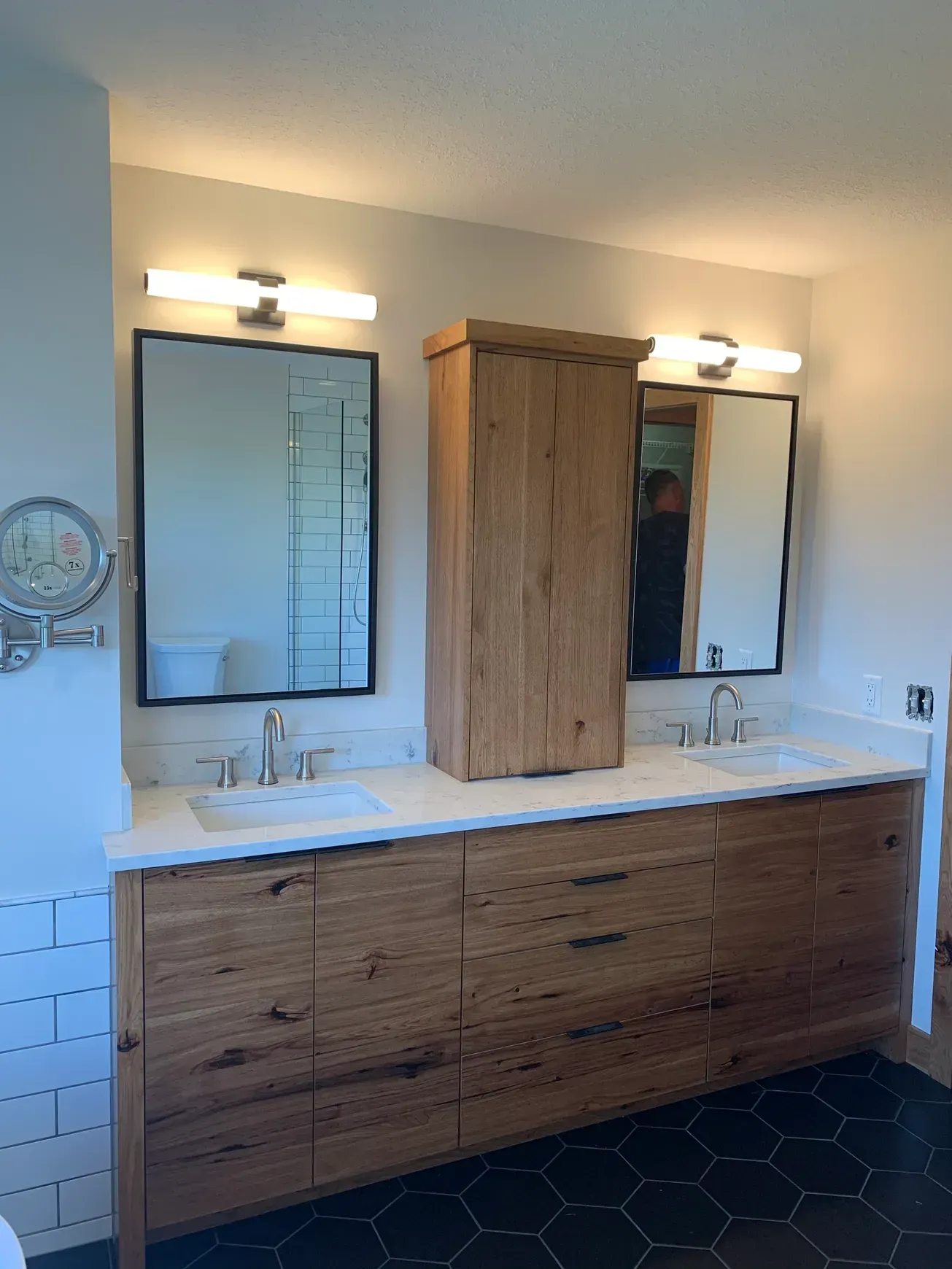 A bathroom with two sinks , a mirror and a cabinet.