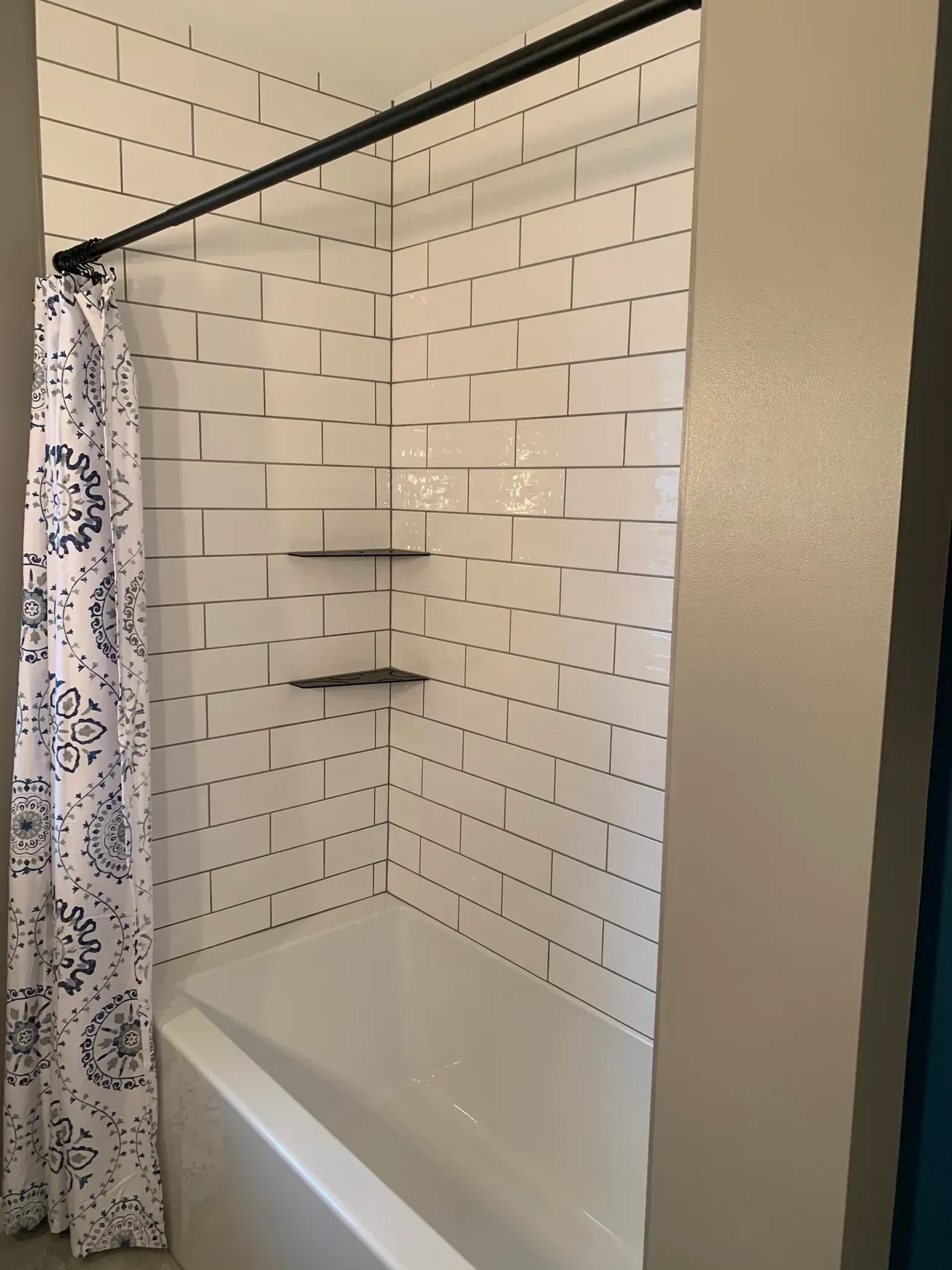 A bathroom with white subway tiles and a bathtub